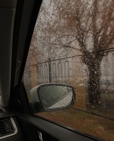 the side view mirror of a car on a rainy day