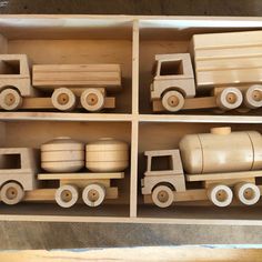 four wooden toy trucks are lined up in a box