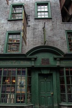 an old building with green doors and windows on the outside, in front of it is a sign that reads florist & birds