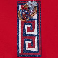 a red, white and blue table runner with some decorations on it