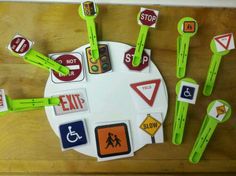 various traffic signs and stickers on a white plate with green handles, around which is a stop sign