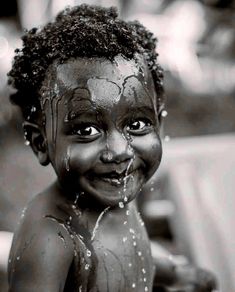 a young child is covered in mud and sprinkled with water from a faucet