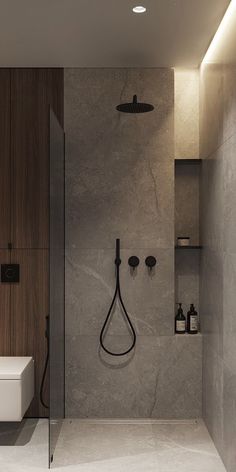 a bathroom with a walk in shower next to a white toilet and wooden wall mounted shelves