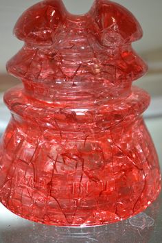 a red glass vase sitting on top of a table