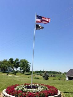 an american flag is flying in the middle of a flower bed