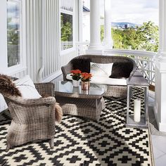 two wicker chairs sitting on top of a black and white checkered area rug