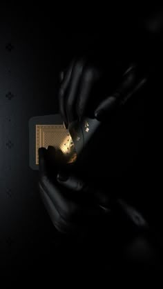 a person holding a cell phone in their hand with the screen lit up at night