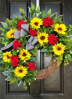 a wreath with red, yellow and green flowers on it is hanging from the front door