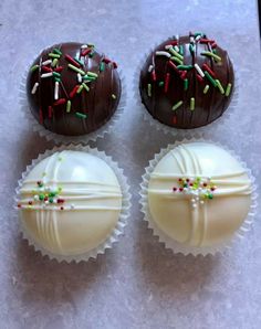 three chocolate covered donuts with sprinkles on them sitting on a table