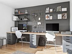 a desk with two chairs and a computer monitor on top of it in a room