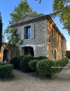 an old stone house surrounded by trees and bushes