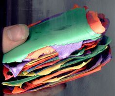 a hand holding a stack of colorful papers