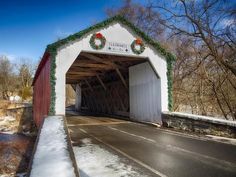 a covered bridge with christmas wreaths on it