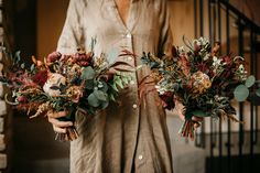 two women holding bouquets of flowers in their hands