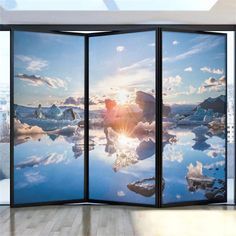 a room divider with an image of the sun setting over water and icebergs