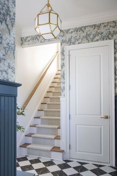 an open door leading to a staircase with blue and white wallpaper