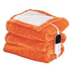 three orange blankets stacked on top of each other with an electric heated blanket plugged in