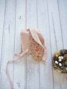 a small hat sitting on top of a wooden floor next to a bird's nest