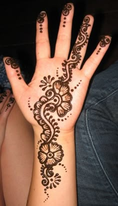 a woman's hand with henna tattoos on it