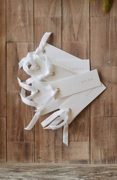 three white napkins tied together on a wooden surface