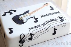 a birthday cake decorated with musical notes and an electric guitar