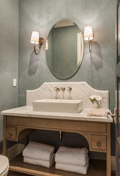 a bathroom with a sink, mirror and towel rack in it's center area