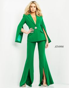 Make a statement in this crepe long sleeve V-neck pantsuit by Jovani 06922. This eye-catching pant suit features a long, figure-flattering silhouette made from luxurious crepe fabric. With its sleek and simple closed back style, this suit is designed to ensure you make an impactful statement. The V-neckline and sleeveless jacket with a beautifully embellished brooch add a touch of modern glamor, while the flared pants with high slits provide a contemporary twist. Perfect for any formal event or business occasion, this suit encapsulates chic and polished fashion effortlessly. Single Breasted V-Neck Pant Suit by Jovani 06922 Designer: Jovani Length: Long Silhouette: Sheath Sleeves: Long Sleeve, Sleeveless Details: High Slit Back Style: Closed Fabric: Crepe Neckline: V-Neck Fit: The model is Crepe Jumpsuit, Portfolio Ideas, Unique Prom Dresses, Navy Fabric, Pant Suit, Wedding Outfits, Women Clothes, Crepe Fabric, Flare Pants