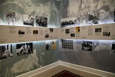 a room with many pictures on the wall and carpeted flooring in front of it