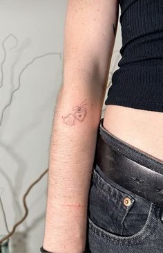 a woman's arm with a small tattoo on the left side of her body