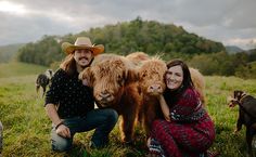 a man and woman pose for a photo with some animals