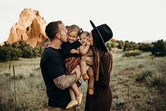 a man and woman are holding two small children