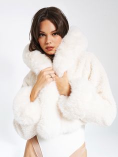 Elevate your style with our high quality Kali Cropped Faux Fur Jacket, a lavish and chic wardrobe essential. Crafted from luxe faux fur, this cropped jacket boasts a soft feel and features an attached hood adorned with a puffy fur trim. Fully lined for comfort, Kali adds a touch of glamour to any special occasion or everyday ensemble. Versatile in white, and also available in black, this jacket promises to turn heads when you walk in the door. Why buy real fur when our faux feels the same! Mater