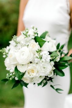 a bridal holding a bouquet of white flowers