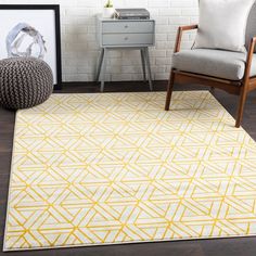 a yellow and white area rug in a living room with a chair, side table and pictures on the wall