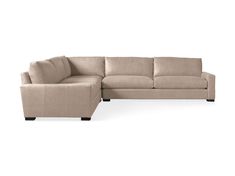 a beige sectional couch sitting on top of a white floor