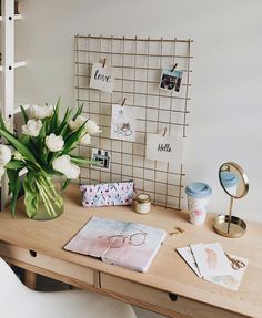 a wooden desk topped with a vase filled with white flowers