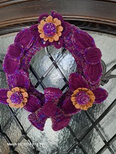 a purple wreath with orange flowers on it