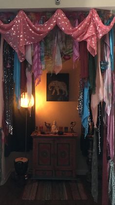 a room filled with lots of different colored clothing hanging from the ceiling and curtains on the walls