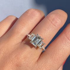 ✦ The Ring Shown in the Picture Holds a Beautiful 1.91 CT Emerald Cut Moissanite. ✦ Main Stone Details✧ Shape: Emerald Cut Moissanite✧ Weight: 1.91 CT (8.50 x 6.50 MM)✧ Color: DEF(Colorless)✧ Clarity: VVS ✦ Side Stone Details✧ Shape: Emerald Cut Moissanite✧ Weight: 1.0 CT (App.)✧ Color: DEF (Colorless)✧ Clarity: VVS ✦ Ring Details ✧ Metal: Gold (10KT, 14KT, 18KT)✧ Metal Tone: Yellow, White, Rose Gold