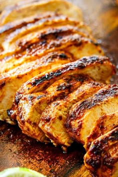 grilled chicken on a cutting board with lime wedges