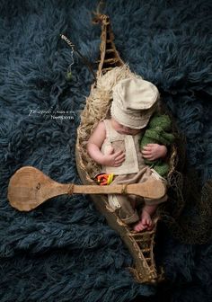 two babies are sitting in a wooden boat