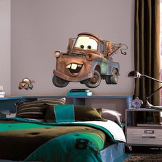 a bedroom scene with focus on the bed and wall decals in the shape of cars