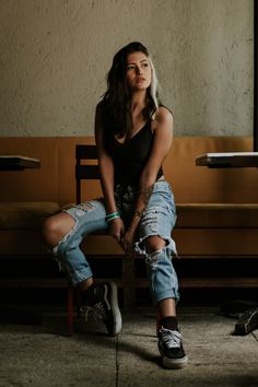 a woman sitting on top of a wooden bench