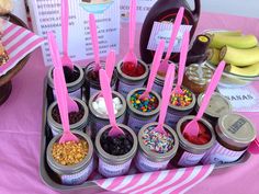 an assortment of desserts and condiments are displayed on a pink tablecloth