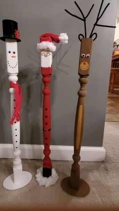 three wooden poles decorated like santa claus, snowman and rudolph the red nosed reindeer