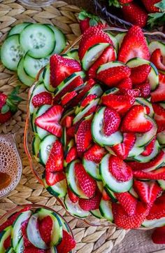 strawberries and cucumbers are arranged in a bowl