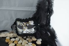 This mask is decorated with feather, and the edges of the mask are decorated with braid. Carefully designed and colored. Decorated with additional glitter for a glamorous look. Worn with silk ribbons attached to sides of the mask. Two tone coating. This mask is about 10 inches tall. The beautiful venetian mask has a very elegant feather adornment on the side. The mask is adorned with feathers, paintings, golden flourish. You fix the mask with a satin ribbon on the back of your head. Color design Artistic Black Masks And Prosthetics For Mardi Gras, Venetian Black Masquerade Mask, Black Masks For Carnival, Black Masks And Prosthetics For Carnival, Black Masks And Prosthetics For Carnival Gift, Artistic Black Masks For Theater, Artistic Black Theater Mask, Artistic Black Masks And Prosthetics For Carnival, Artistic Black Masks For Carnival