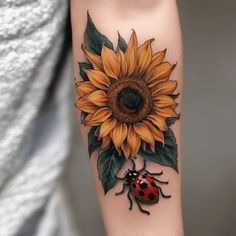 a ladybug and sunflower tattoo on the arm