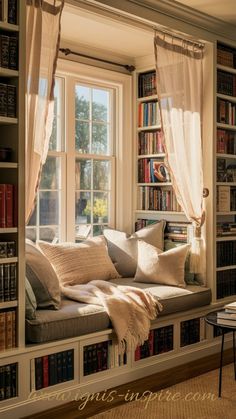 a window seat in front of a book shelf filled with lots of books and pillows