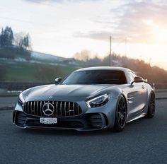 the mercedes amg gt is driving down the road at sunset or sunrise, it's hard to tell